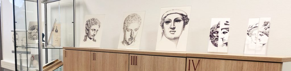 Dessins de visages de statues grecques exposées sur les meubles de la bibliothèque.